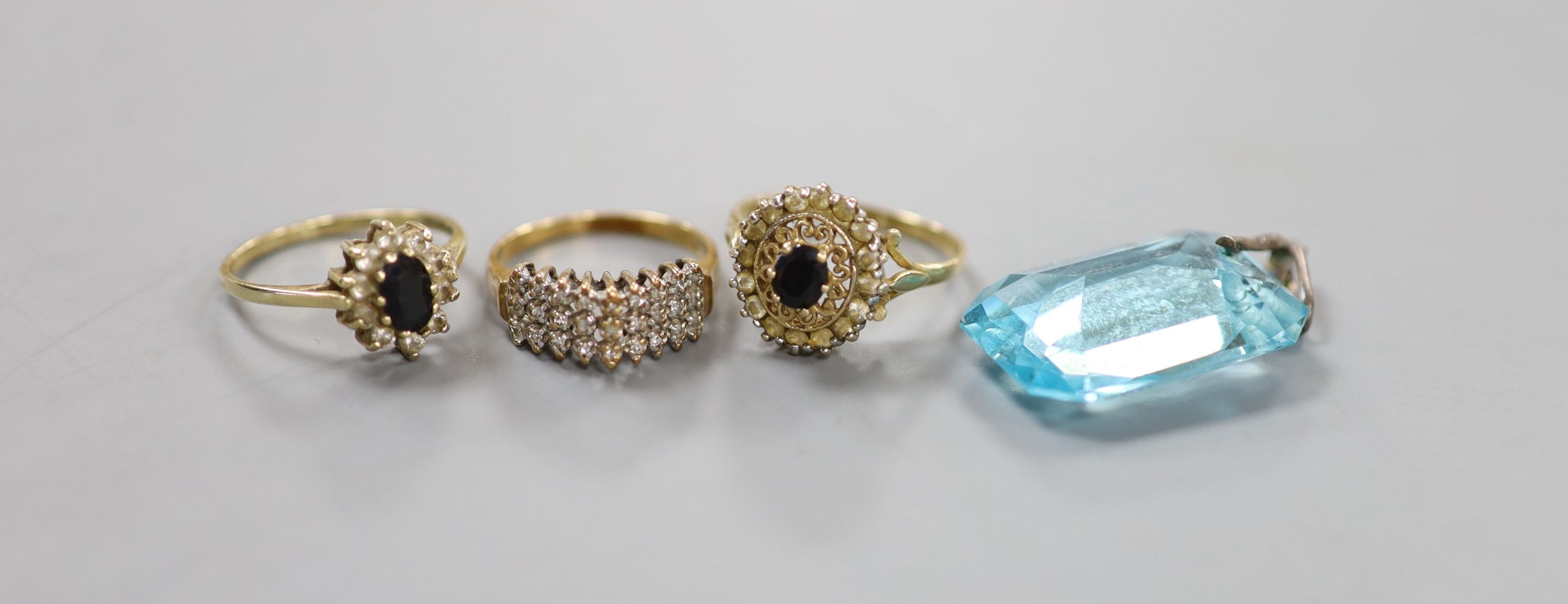 Three assorted modern 9ct gold and gem set rings, gross 6.5 grams and a paste pendant.